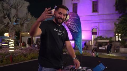 a man wearing a black tshirt and headphones waving with his hand