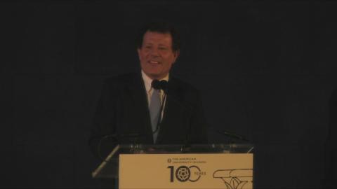 A man is standing at a podium talking into a microphone