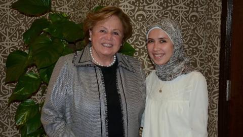 Two women standing next to each other, one is veiled and the other one is not veiled