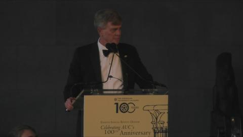 A man is standing at a podium talking into a microphone