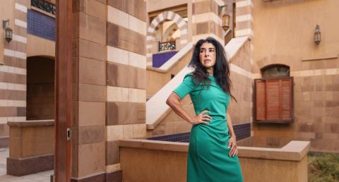 A woman is standing, she has one hand on her waist