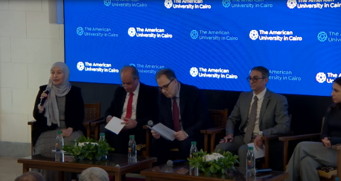 Three males and two females are sitting in a panel discussion