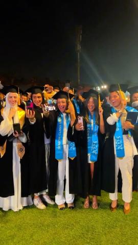 Females wearing their graduation caps and gowns. They are happy