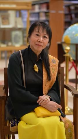 Mrs. Jane Ittogi Shanmugaratnam, First Lady of Singapore is sitting on a chair next to a globe in a library