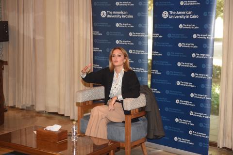 Professor Seham Elmrayed speaks in front of a step-and-repeat