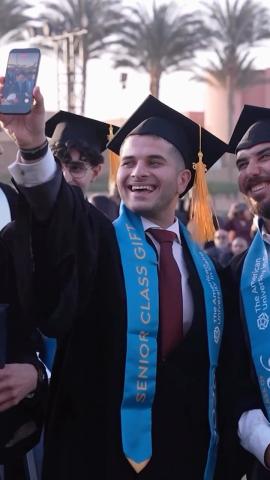 Males are wearing their caps and gowns. They are smiling