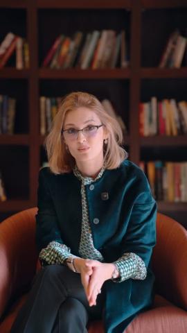 A woman is sitting on a chair in a library