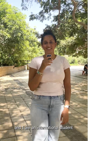 a girl walking on campus enjoying the gardens