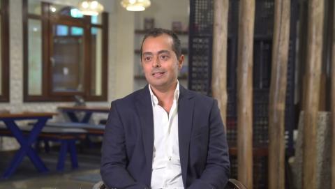 A man is sitting on a chair and smiling