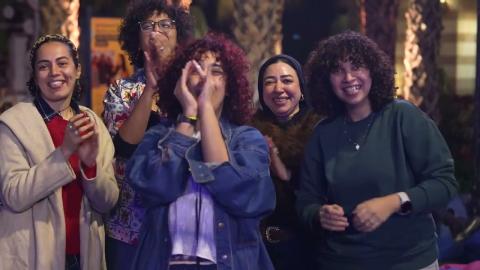 Five females standing, smiling and cheering