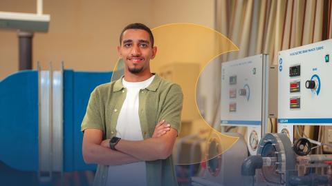 A male is standing and smiling in a lab.