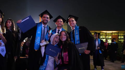 Males and females are smiling. They are wearing their graduation caps and gowns
