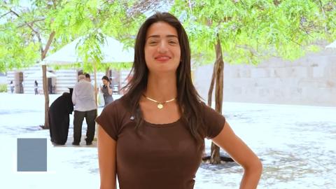 A female is standing and smiling 