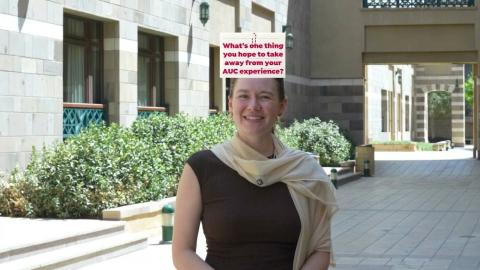 A female is standing and smiling. Text: What's one thing you hope to take away from your AUC experience?