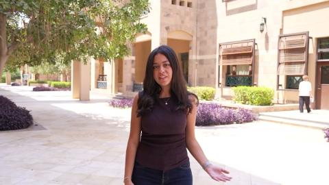 A female is standing and smiling 
