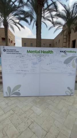 A big white board. Text: The American University in Cairo. Mental Health Expressions. #AUCWellbeing