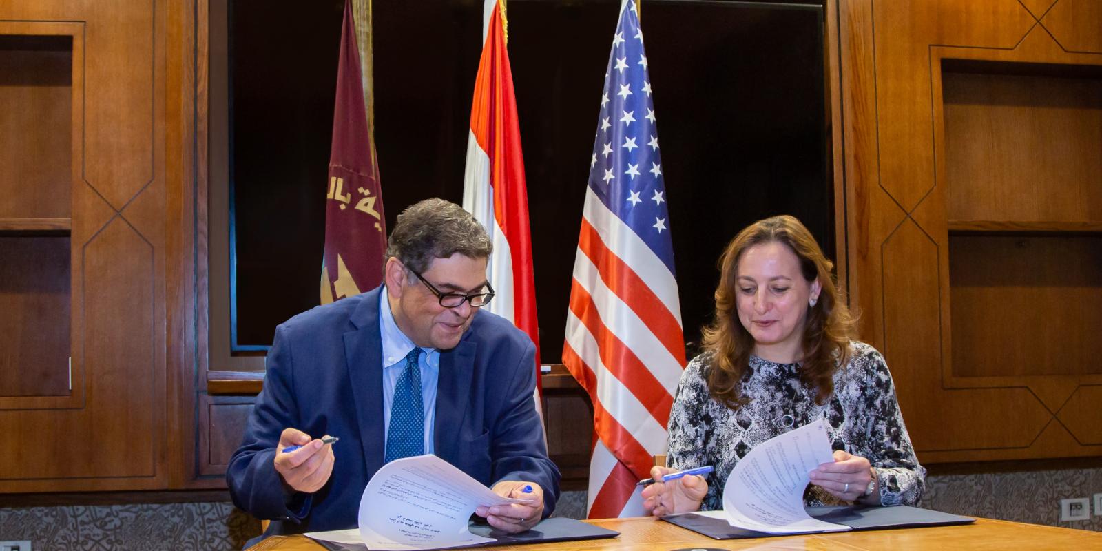 AUC Counselor Ashraf Hatem and NMI Executive Director Sherifa Fouad Sherif sign the memorandum of understanding