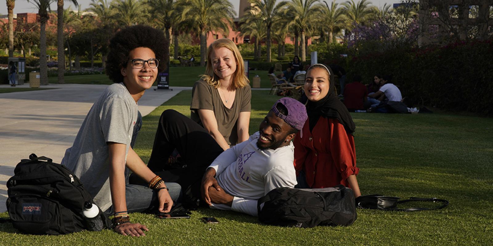 AUC international students sitting in the campus gardens. 
