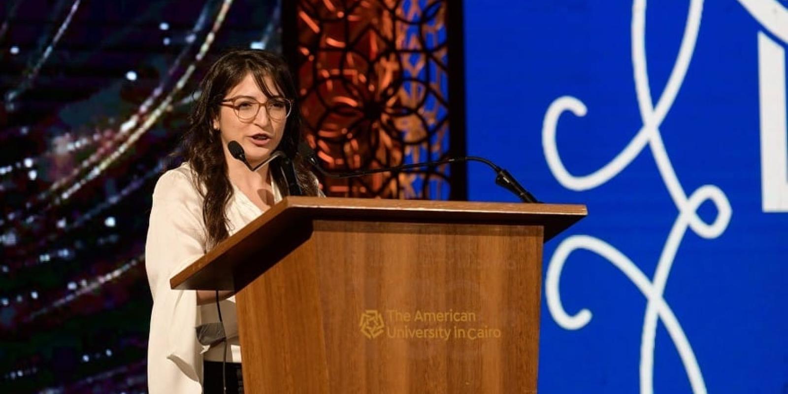 Girl speaking in the microphone on the podium