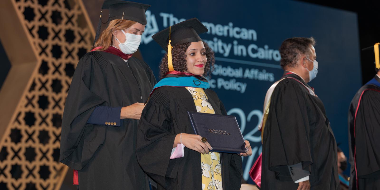 Girl with cap and gown holding a certificate