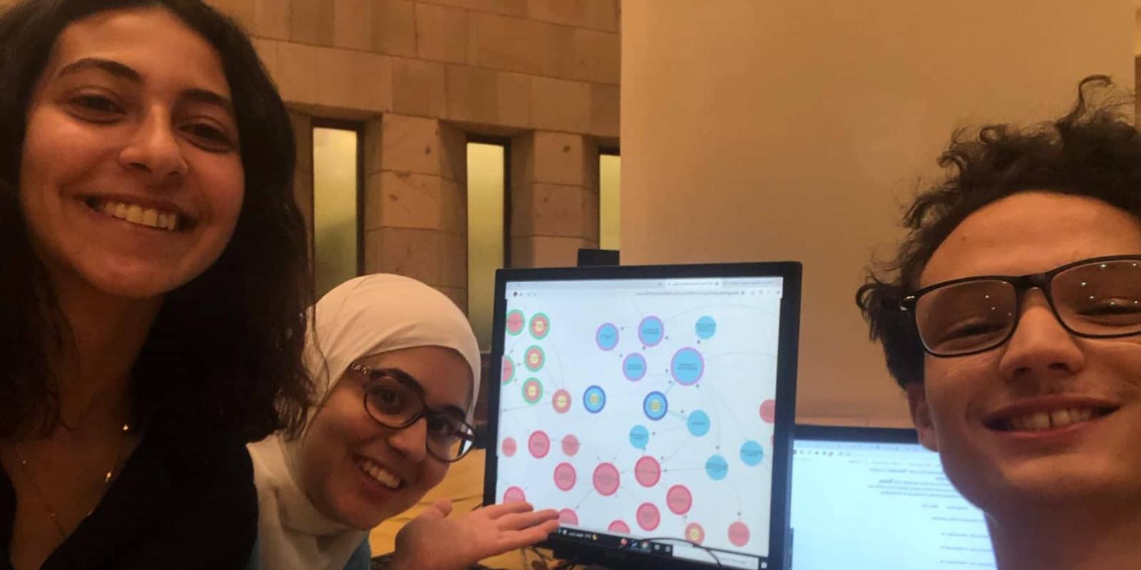 students smiling by the computer