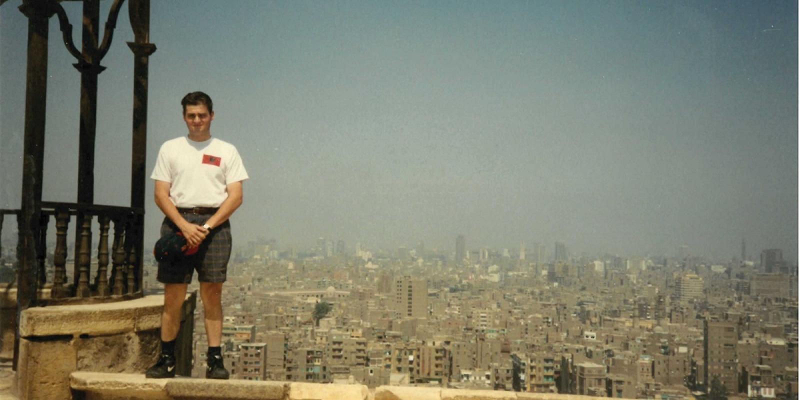 a man dressed in a tshirt and shorts standing on top of a building