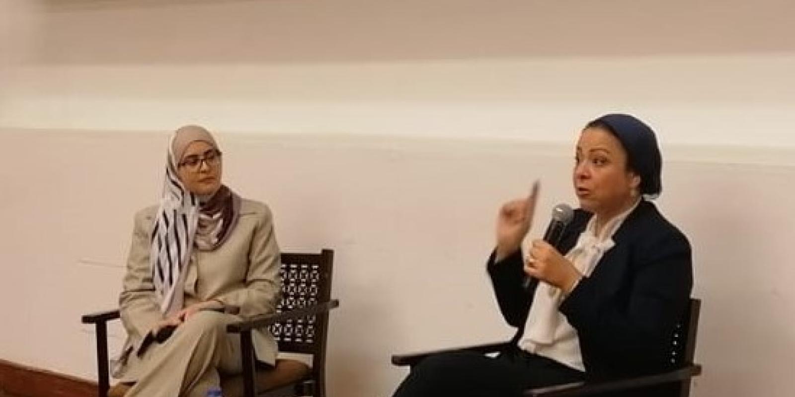 two ladies sitting next to each other in a panel discussion
