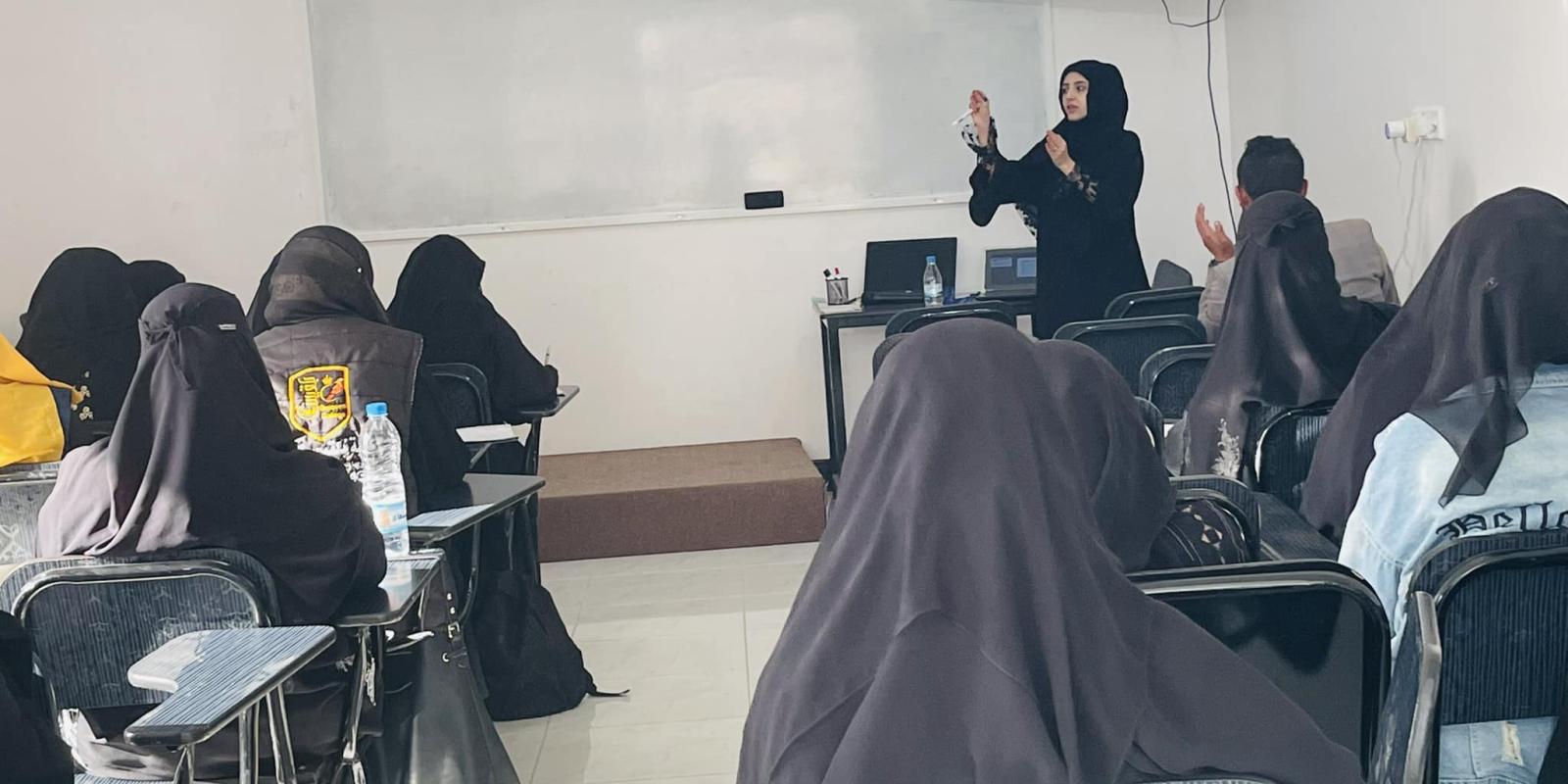 Back view of a classroom of veiled women