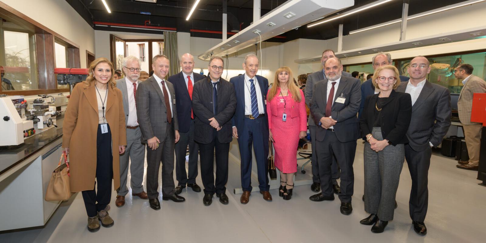 The Board of Trustees, faculty and staff visit Eltoukhy Learning Factory, pose in a line in front of lab equipment