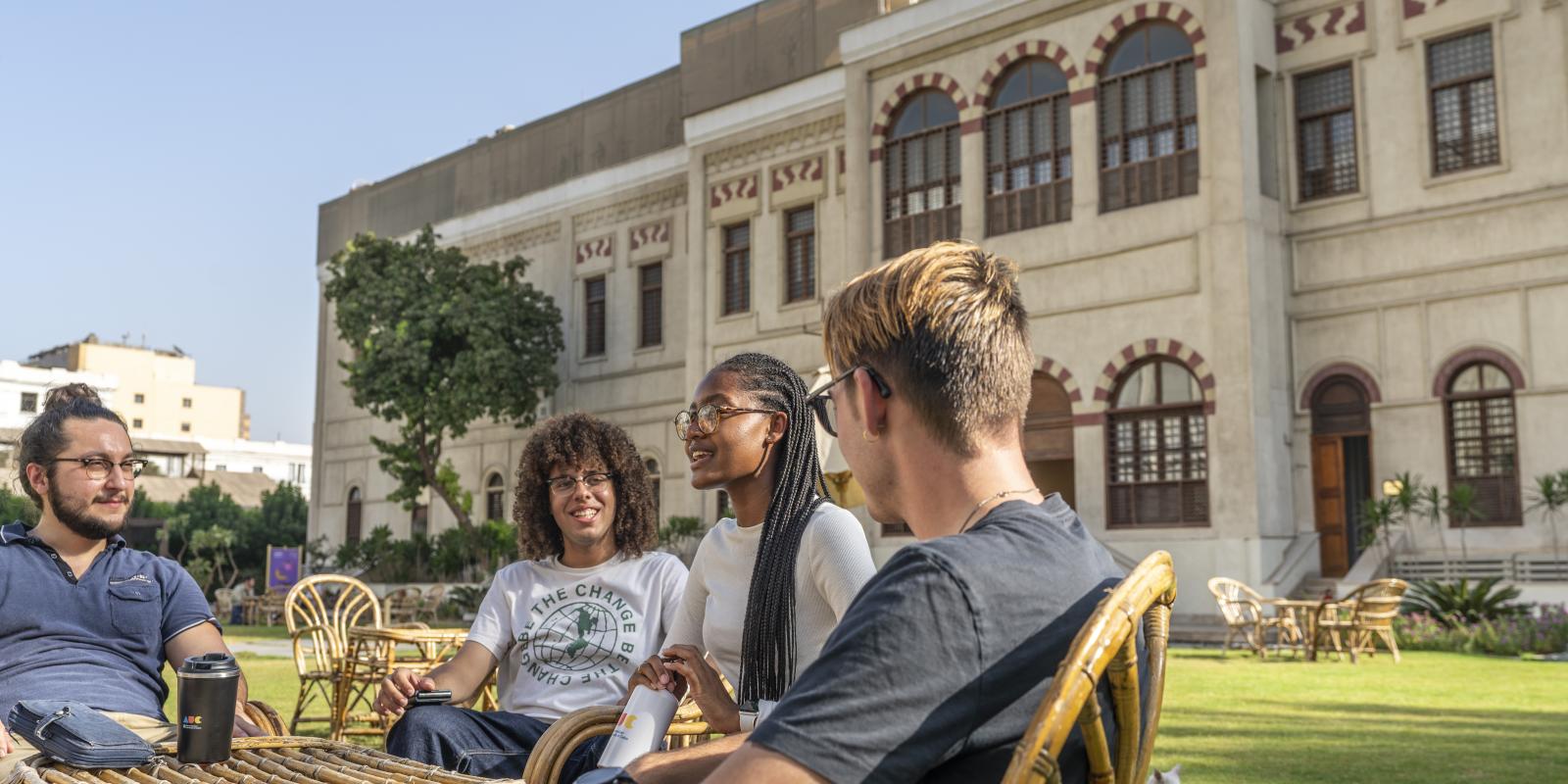 students in group in tahrir campus garden discussing a project