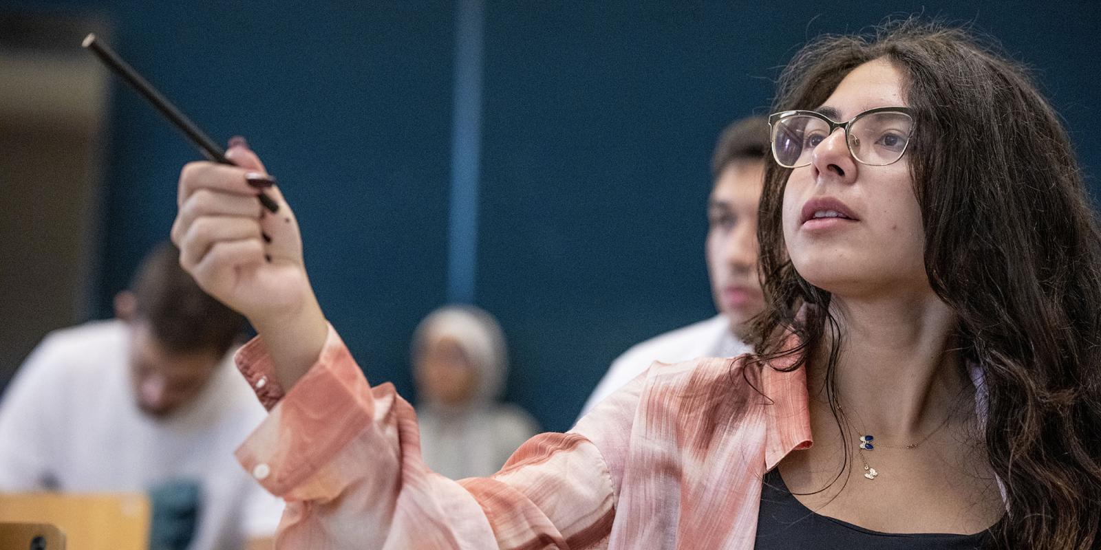 Girl wearing glasses sitting in class 