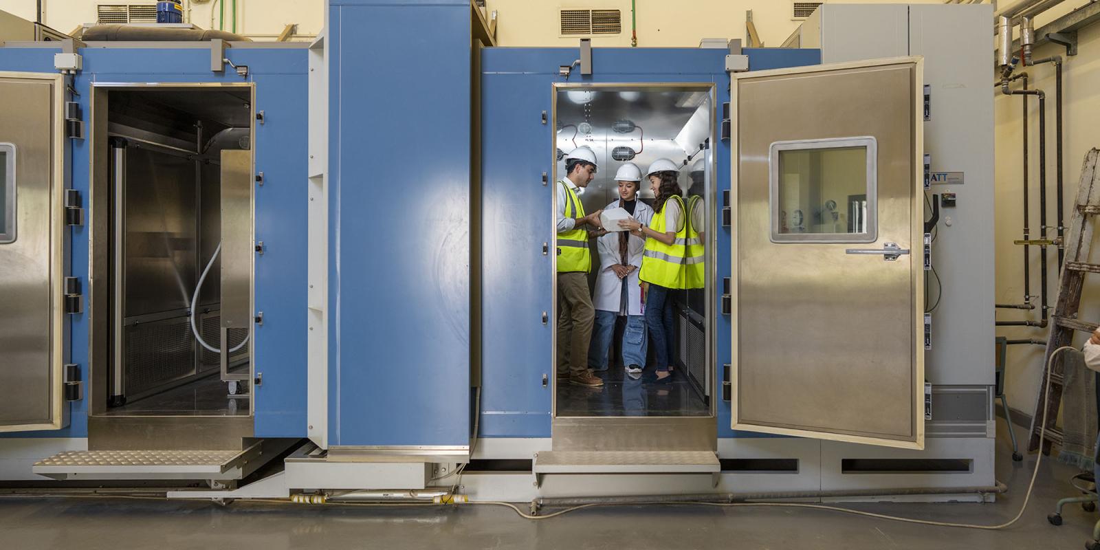 Two girls in a construction lab wearing yellow safety vests