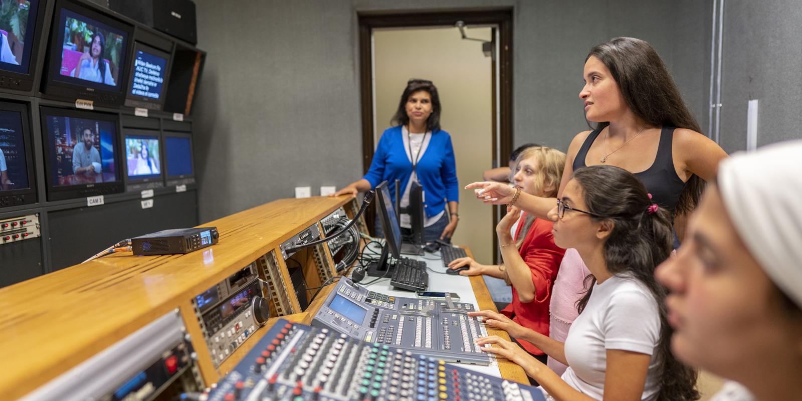 Crew and female students inside a studio control room