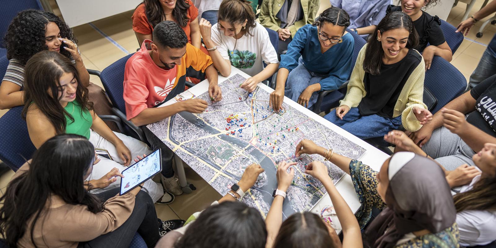 Students sitting around a map and discussing it together