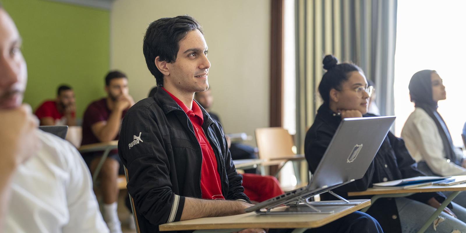 global affairs program image of students in class with focus on a smiling male student