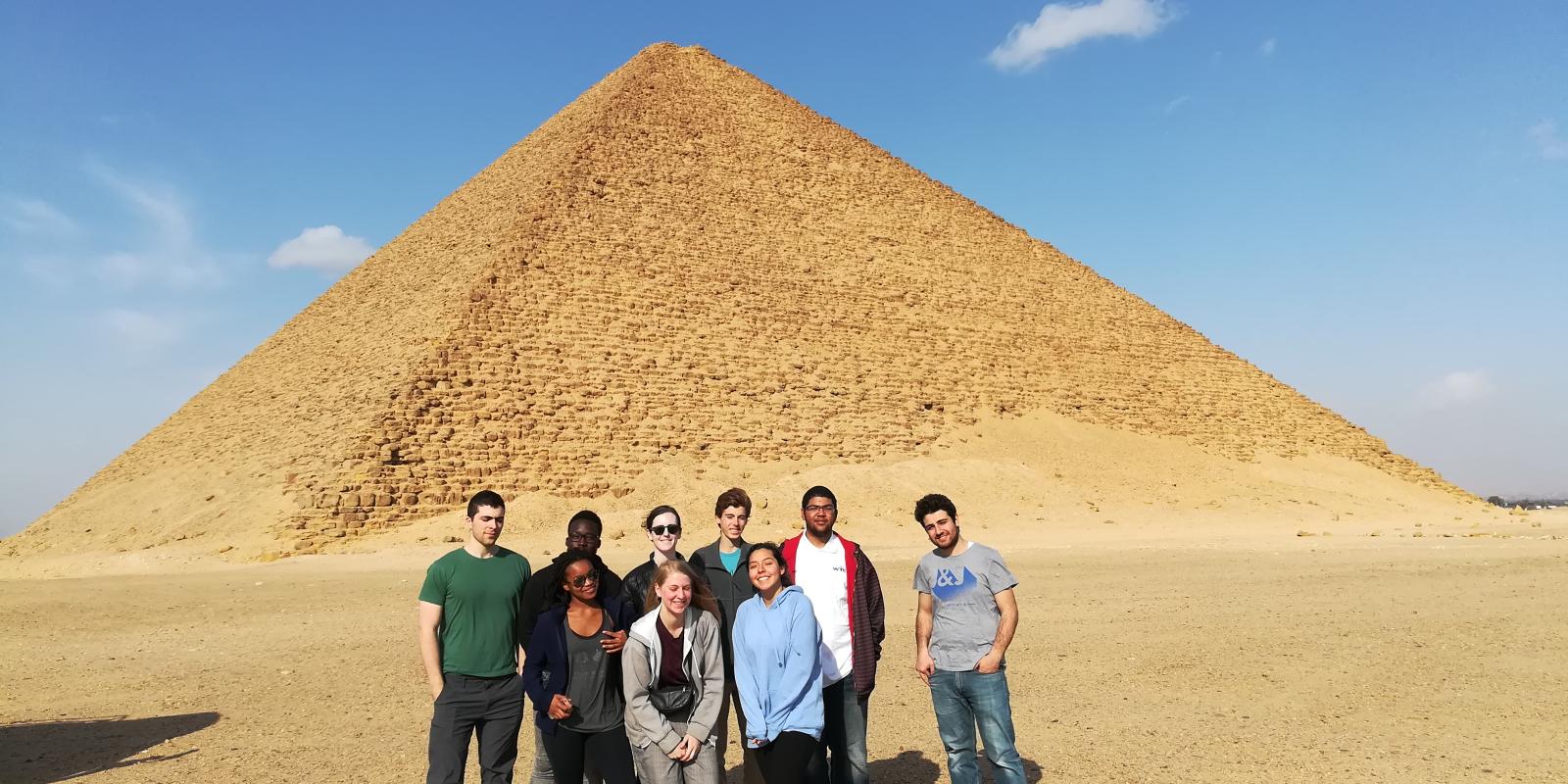 A group of girls and boys standing by the pyramids
