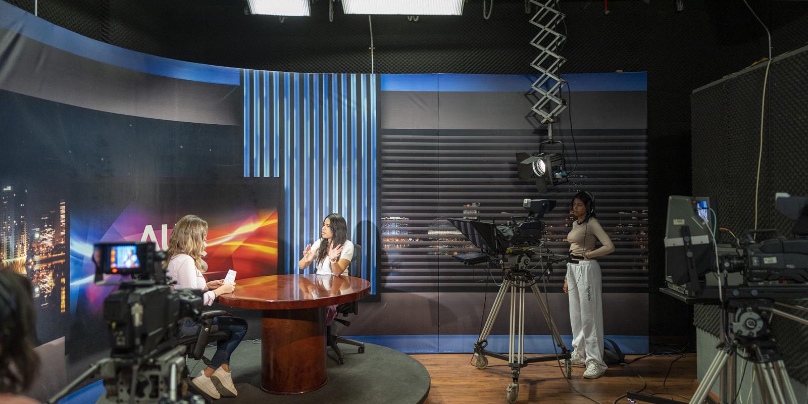 TV and journalism program image of a TV studio and students working in front and behind the camera
