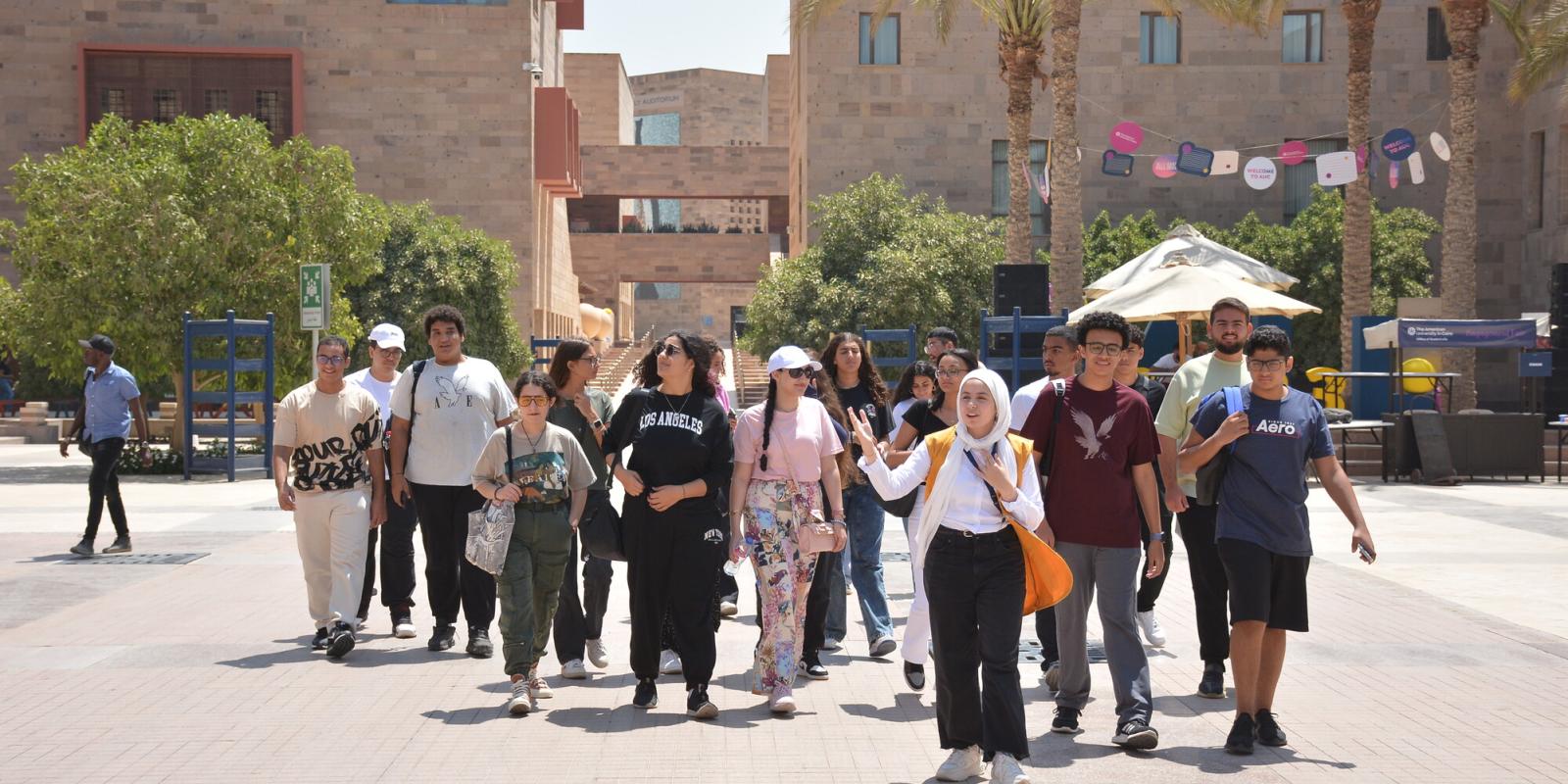 A group of girls and boys walking on campus 