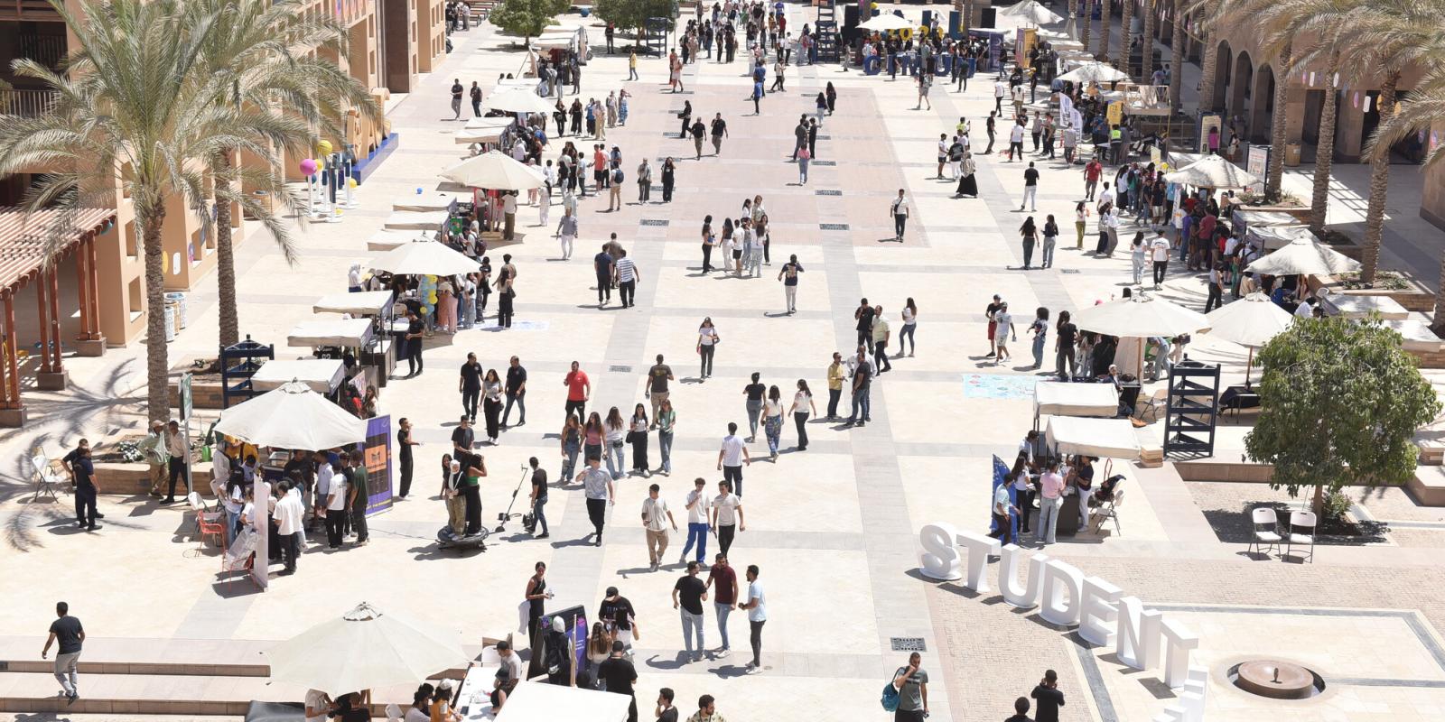 An upper shot of AUC plaza with students walking