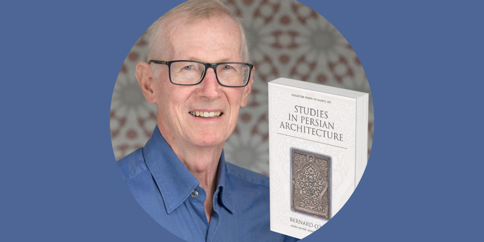 Man in a blue shirt and glasses with a book cover that reads "Studies in Persian Architecture"