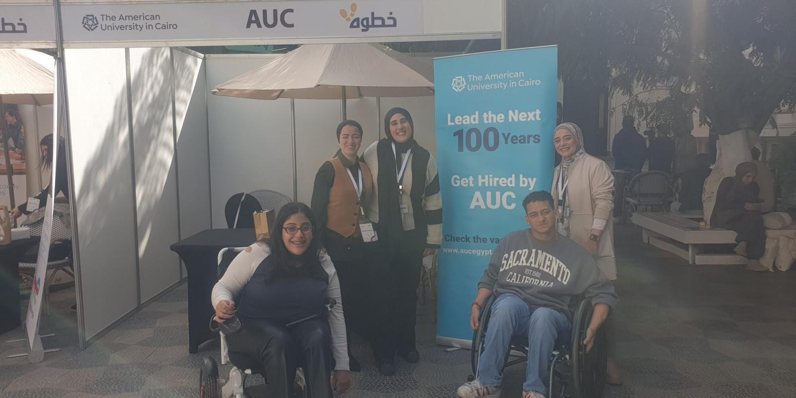 AUC HR team standing at booth, participating in Helm fair 