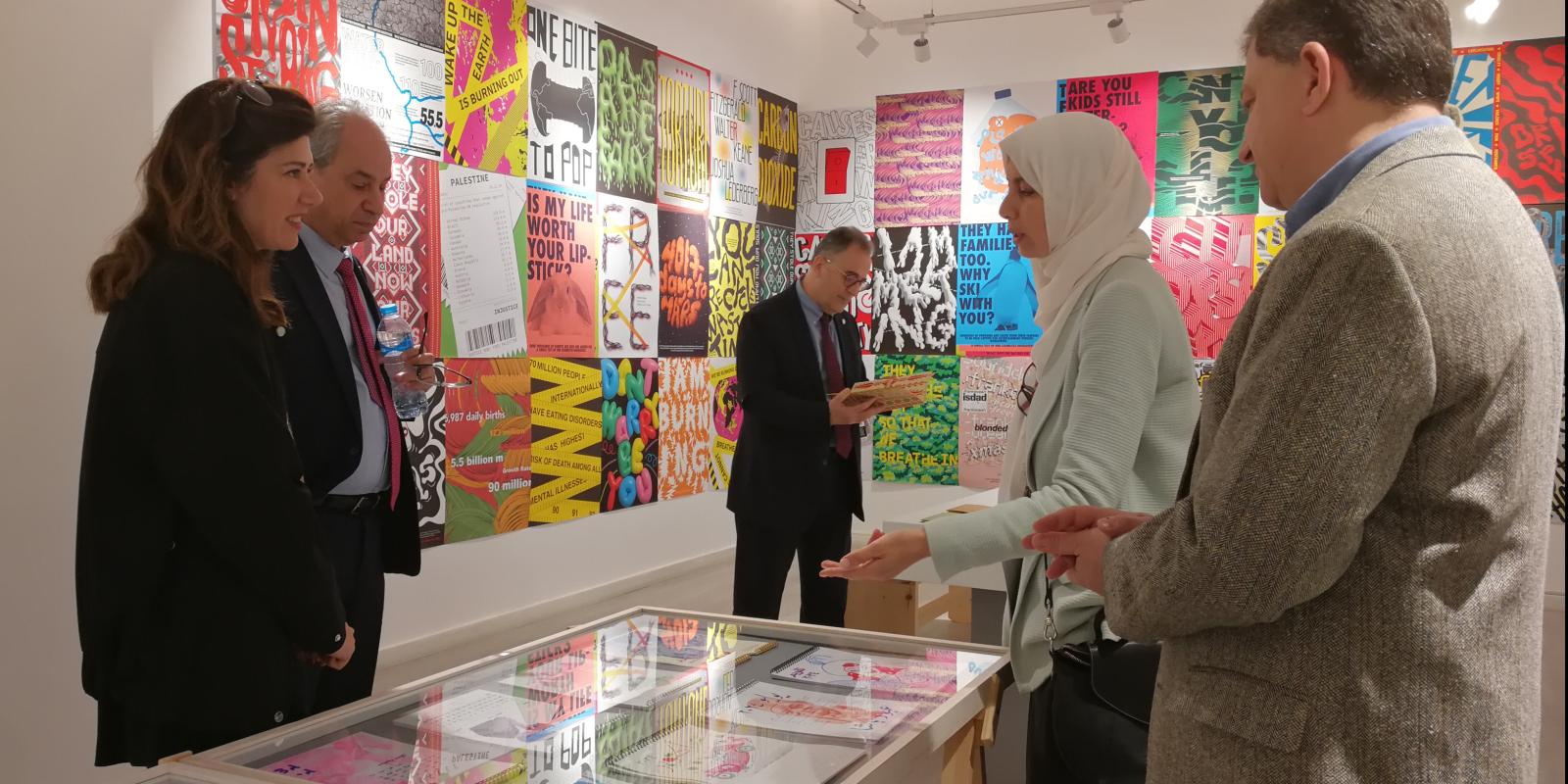 People standing around a gallery with colorful images displayed