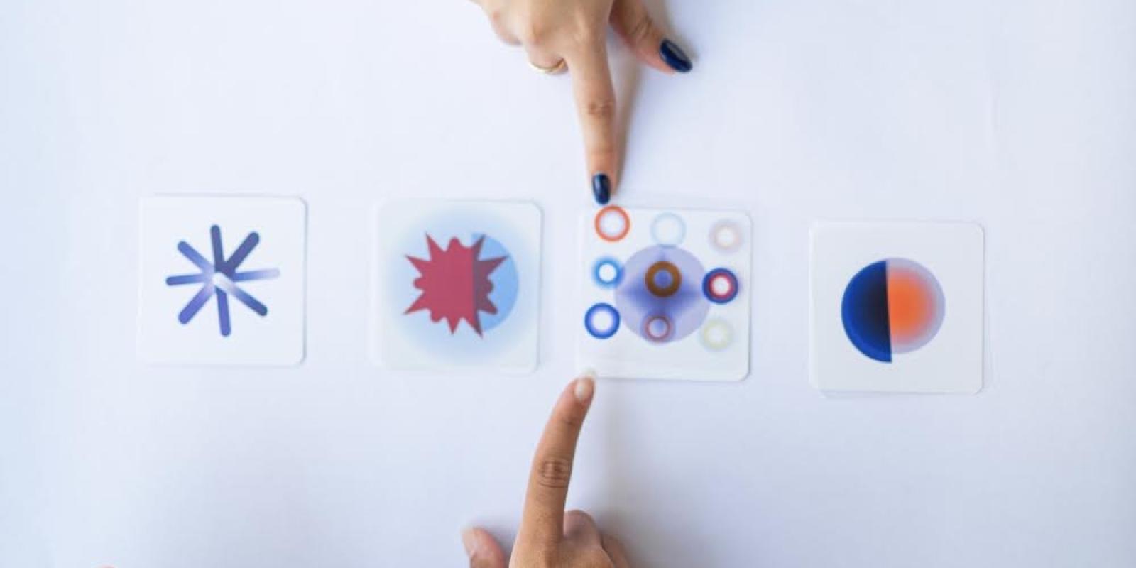 Two hands point to cards showing calming circular graphics
