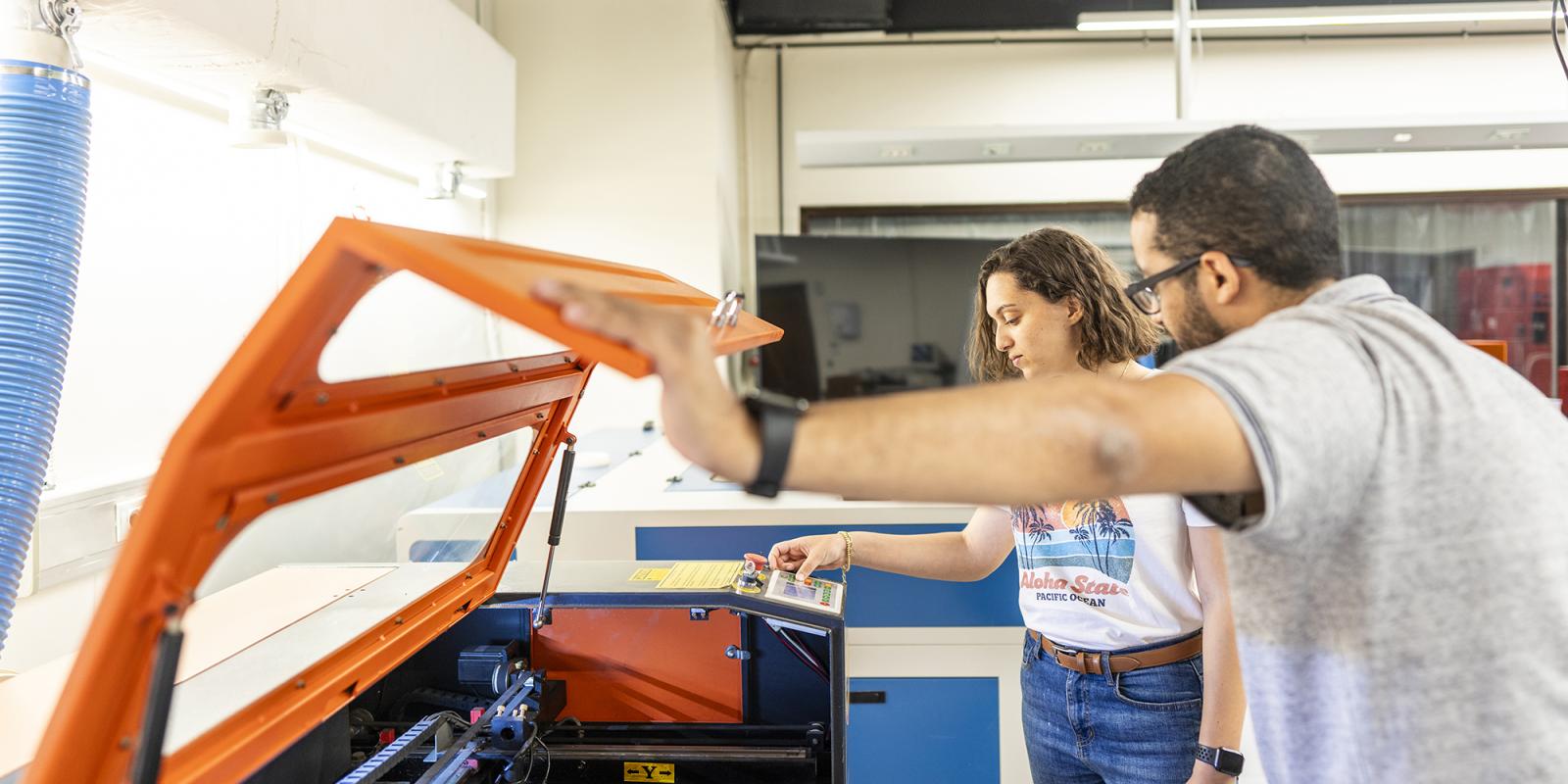a girl and a boy working on an experiment in a lab