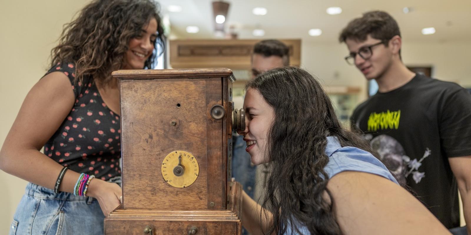 a group of students looking into a wooden time machine