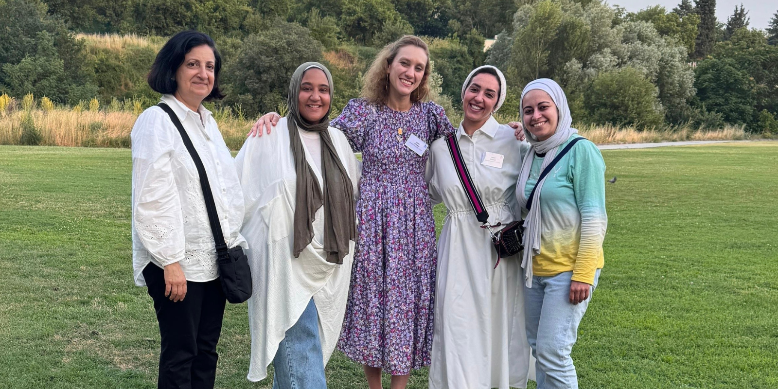 a group of women standing together taking a group photo in the gardens