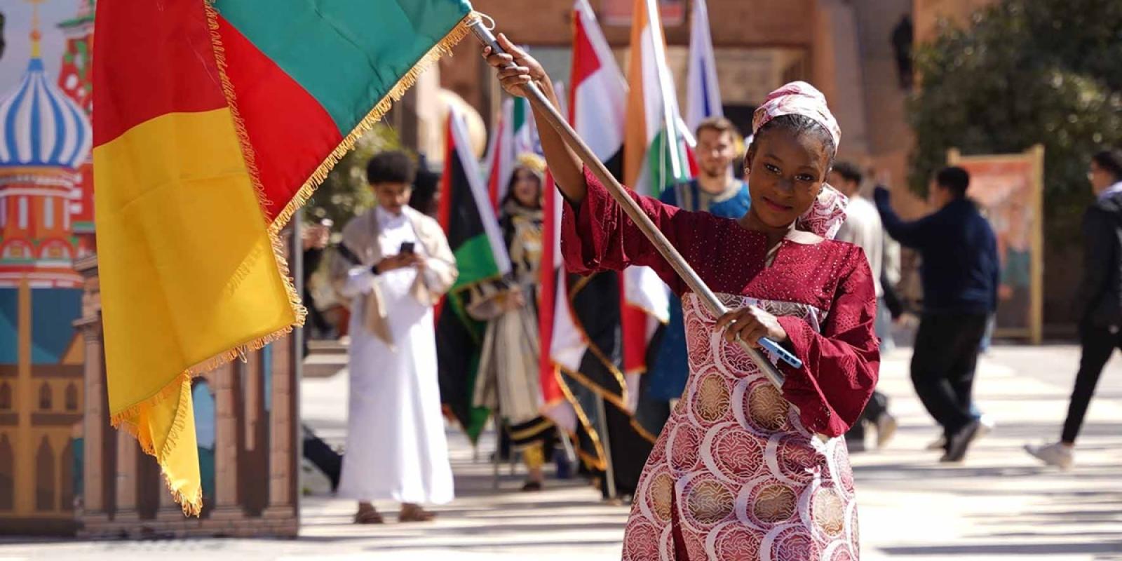 A girl walking with the Cameron  flag