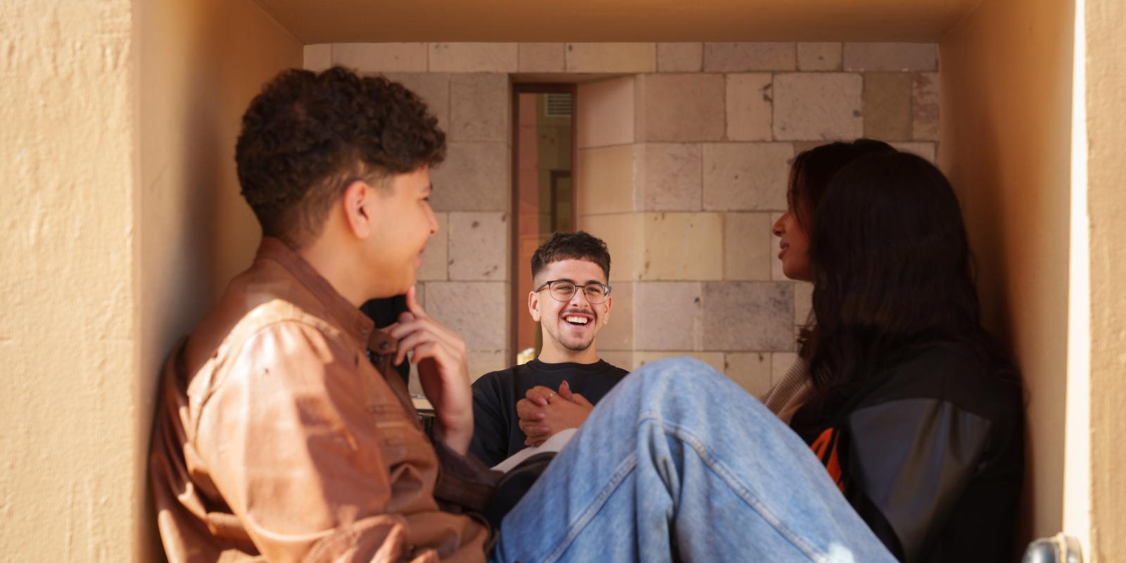 a girl and a boy sitting in the cubes with one student smiling at them