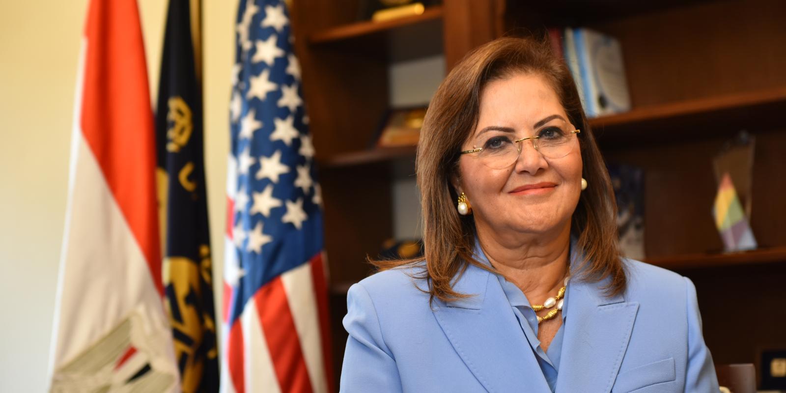 Hala Elsaid standing in front of an Egyptian and American flag