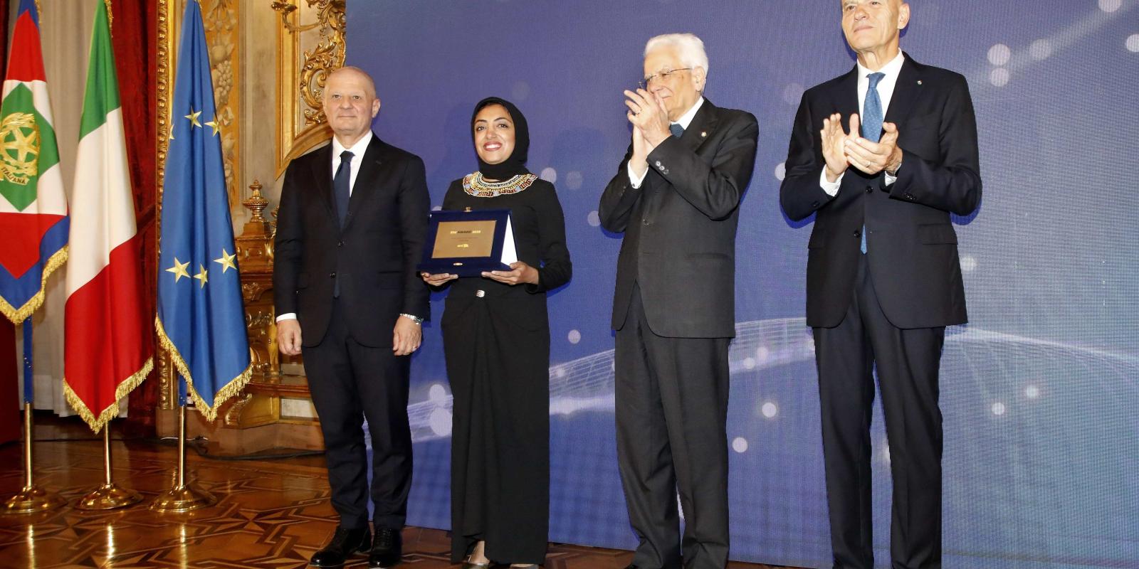 Shima Farag is standing between the President of Italy and the CEO of Eni Company